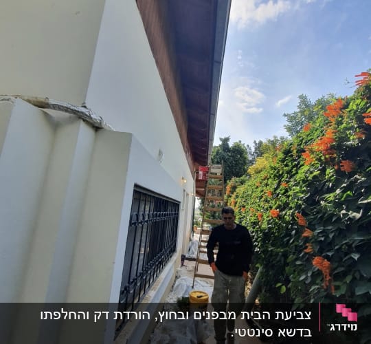 אדם ליד סולם, דלי וחומרי בנייה על הרצפה